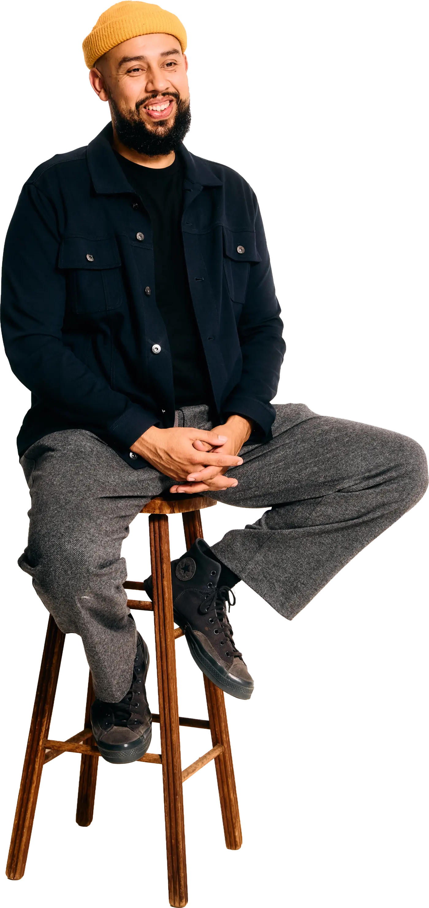 Jesús Trejo seated on a wood stool, smiling